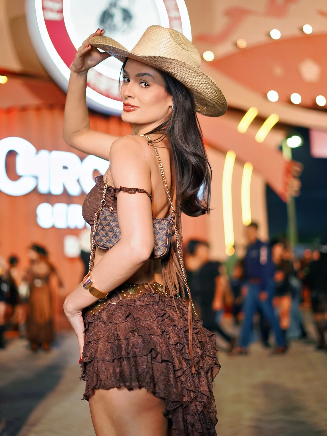 Débora Xavier de chapéu de palha e conjunto marrom de babados na festa de Barretos